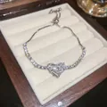 Detail shot of a sparkling heart-shaped zircon bracelet displayed in a wooden jewelry box. - Heart Style (HB779) / 23CM / Silver