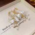 Detail view of elegant pearl flower tassel earrings with zircon-inlaid gold hoops. - Gold