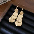 Vista dettagliata di eleganti orecchini pendenti in oro opaco con dischi rotondi - Gancio per orecchio - Oro