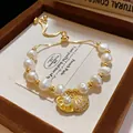 Close-up of a gold-plated pearl bracelet with a zircon shell pendant in a gift box - Gold - Shell