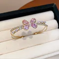 Close-up of elegant double-layered open bangle with pink zircon butterfly detail - Bangle-Pink Zirconia / Gold