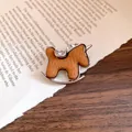 Elegante spilla a cavallo a dondolo marrone con strass scintillanti su una pagina di libro - 7# Vintage Caffè Argento