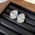 Primo piano di orecchini a lobo in acrilico argento con texture metallo liquido - Forma Increspata Irregolare (2)