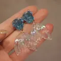 Handmade blue rose stud earrings with iridescent translucent mermaid tail charms - Blue Rose Fishtail Dangle Earrings / Iridescent Blue