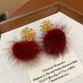 Close-up detail of elegant gold firework stud earrings with deep red fur pom-poms - Gold Fireworks Red Fur Ball (HE29425)