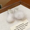 Close-up view of elegant snowflake stud earrings featuring fluffy white faux fur pom-poms - Silver Fireworks White Fur Ball (HE29425)