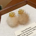Detailed close-up of elegant starburst stud earrings featuring soft beige fur pom-poms - Gold Fireworks Coffee Fur Ball (HE29425)