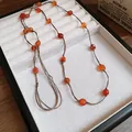 Close-up detail of a vintage ethnic colorful glass bead necklace in a white display box - 20# Necklace - Brown & Red