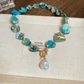 Detail of irregular iridescent glass beads and baroque pearl pendant on gold OT buckle necklace - 29# Necklace - Gold & Blue with Artificial Pearl