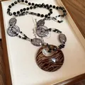 Vista dettagliata di una collana retrò in acrilico con ciondolo tigre e perle screpolate - Collana 69# - Nera - Stampa Zebra