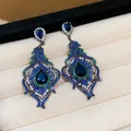 Macro detail of vintage peacock feather drop earrings featuring blue and green zircon stones - Silver Post Feather Jewelry / Silver-Blue