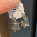 Macro detail of irregular silver-colored wire-wrapped design hoop earrings - Irregular Winding Style (HE10656) / Silver