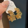 Detailed view of gold-plated geometric hoop earrings with intricate wire-wrapped design - Irregular Winding Style (HE10656) / Gold