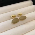 Close-up of elegant French retro coffee-colored oval drip oil earrings on velvet tray - Oval Earrings (HE10963)