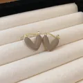 Close-up of French vintage heart earrings in coffee color enamel on jewelry tray. - Heart Ear Clip (HE16365)