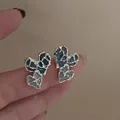 Detailed macro view of abstract blue enamel heart earrings with a shiny silver finish - Irregular Gold Edge Blue White Gradient Enamel Heart (19#)