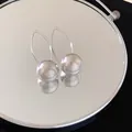 Macro detail of silver spherical earrings with radiating texture and elegant wire hooks - Silver