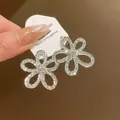 Primo piano di alta qualità di orecchini a fiore con strass dal design argento brillante. - Argento