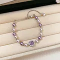 Detailed macro view of a French pearl bracelet featuring a sparkling square purple zircon - Bracelet