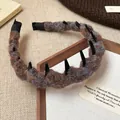 Detailansicht eines gestrickten Woll-Hairreifs mit schwarzen Zähnen für hohes Volumen. - Grau