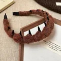Detailansicht der Strickstruktur und Kammzähne dieses stilvollen braunen Stirnbands. - Braun