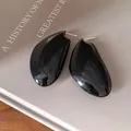 Primo piano di orecchini a goccia neri lucidi con elegante design vintage francese minimalista. - Nero