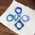 Close-up macro view of five irregular marbled acrylic geometric rings in various blue tones - Irregular Geometric (5853155184857)