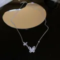 Elegant butterfly pendant necklace with sparkling crystals on black reflective surface. - Style 40 (Hollow Out)