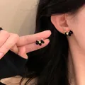Elegant black flocked pony stud earrings with golden accents worn on model's ear - Pony Shape (Silver Post) / Gold-Black