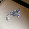 Primo piano della spilla ad ala di farfalla con gemme viola, verdi e una perla. - Farfalla Strass Colorati (9#)