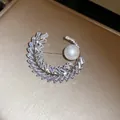 Primo piano dettagliato di una spilla a mezzaluna in zircone con una lucente perla bianca - Spiga di Grano Mezzaluna (7#)