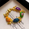 Vintage palace style bracelet featuring colorful enamel egg charms and golden bows - Style 7 Bracelet