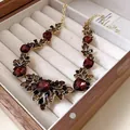 Vintage gold-tone necklace with large red gemstones and crystal leaf details in a display box. - Necklace Style 25