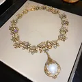 Vintage palace style gold necklace featuring a large pearl pendant and crystal accents - Necklace Style 32