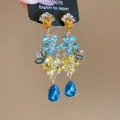 Macro view of luxurious floral earrings featuring colorful teardrop crystals on a display card - 25# Silver Post Tiered Dangle Floral