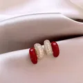 Dettaglio di orecchini a lobo in smalto rosso e pavé di strass su elegante seta chiara - 6# Stile Capsula Strass (Oro Rosso)