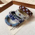 Close-up detail of four fabric printed elastic hair ties in varied blue and brown patterns - Set of 4 / Blue, Coffee