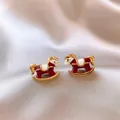 Primo piano di orecchini a cavallo a dondolo rossi e bianchi con tocchi dorati - 10# Stile Cavallino a Dondolo Divertente (Oro Rosso)