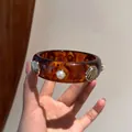 Bracciale rigido vintage in resina con conchiglia e perla, motivo a guscio di tartaruga - Marrone