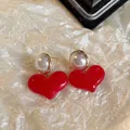 Gros plan de boucles d'oreilles cœur rouge élégantes avec perles sur fond texturé. - Style Cœur (3#)