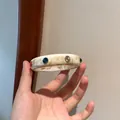 Bracciale rigido retrò in resina con pietre colorate e trama marmorea elegante. - Marble