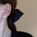 Detail view of an elegant large white pearl stud earring worn on a model's ear lobe - Silver Pin - White 14mm