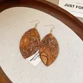 Close-up detail of teardrop earrings with butterfly print on wood texture. - Butterfly Design / Coffee