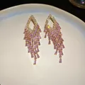 Detailed view of luxury pink crystal tassel earrings with sparkling cubic zirconia - Silver Earring Post - Gold - Pink
