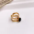 Close-up detail of a gold stainless steel open ring featuring a round black zircon gemstone. - Ring #29 - Gold - Black