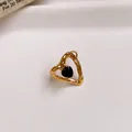 Detailed macro shot of a gold-toned hammered heart ring with a black zircon center. - 22# Ring - Gold - Black