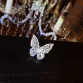 Close-up detail of a luxury sparkling zircon butterfly open ring on black leather surface. - Butterfly Design / Adjustable Open / White