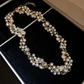 Close-up detail of a vintage style pearl and rhinestone necklace on black velvet - Necklace Style 37 / Gold