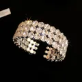 Close-up of elegant metal open bracelet with three rows of sparkling rhinestones. - Three-Row Style (HB5239) / Silver