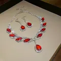 Détail d'une parure de bijoux avec pierres rouges, collier et boucles d'oreilles. - Argent Rouge